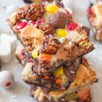Candy Overload Magic Bars | Annie's Noms - An Oreo base is topped with condensed milk, shredded coconut and a myriad of candy creating a soft gooey, chocolatey magic bar!