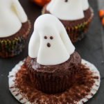 A chocolate frosted cupcake with a fondant ghost atop it; these Ghost Cupcakes are treats that adults and kids alike will love! #ad