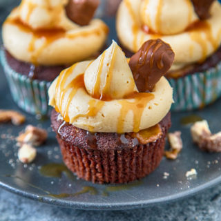These Twix Cupcakes are out of this world amazing! A soft, rich chocolate cupcake filled with bits of Twix and topped with caramel frosting and sauce!