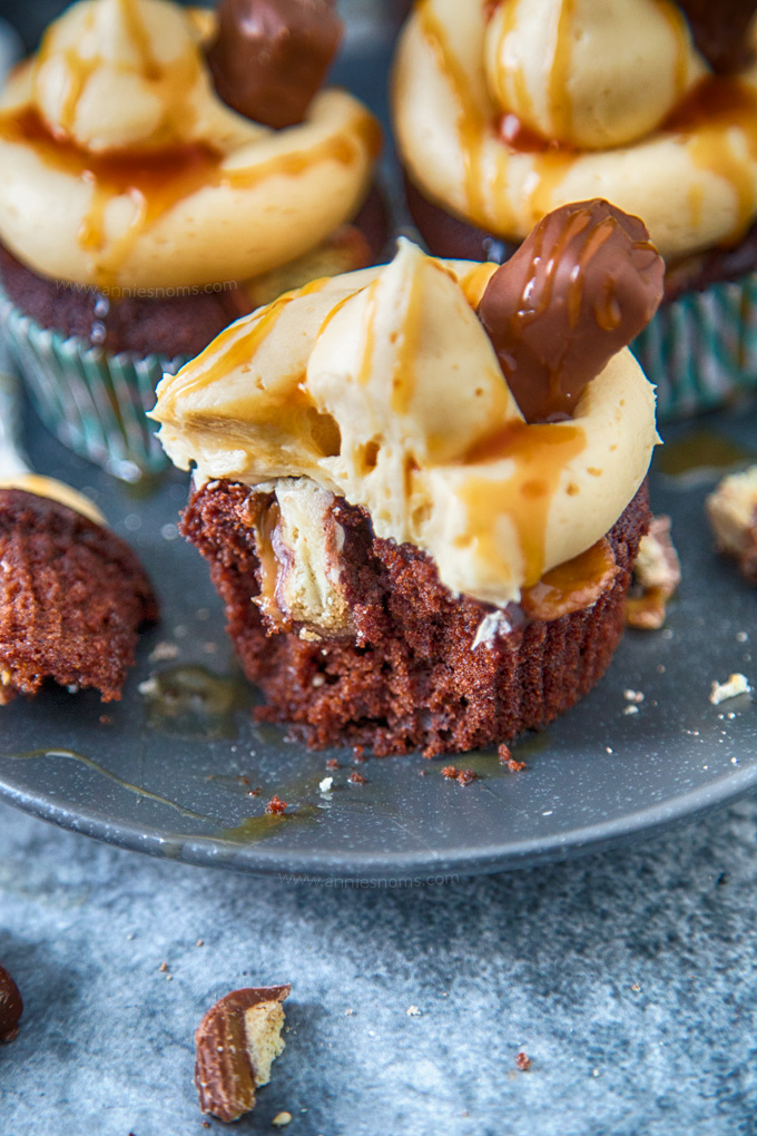 These Twix Cupcakes are out of this world amazing! A soft, rich chocolate cupcake filled with bits of Twix and topped with caramel frosting and sauce!