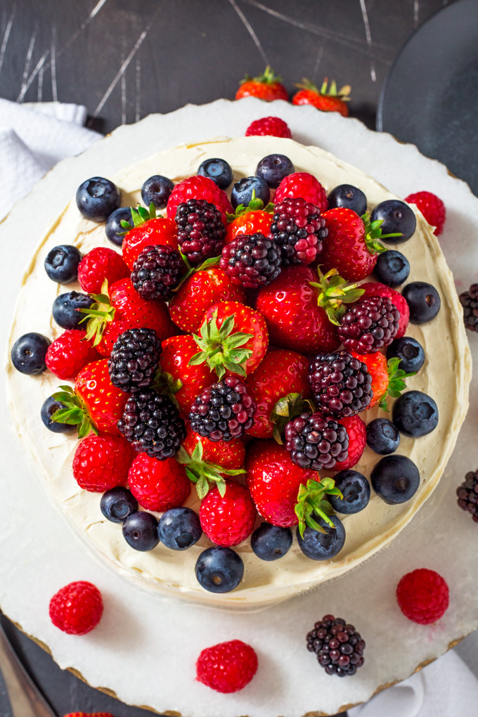 This Summer Berry Layer Cake is the ultimate cake for the berry lovers in your life with layers of vanilla cake, homemade berry jam and a myriad of fresh berries on top.